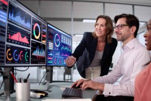Business students analyzing data on computer screens