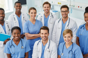 Smiling medical team, including doctors and nurses, representing a happy and united healthcare team.